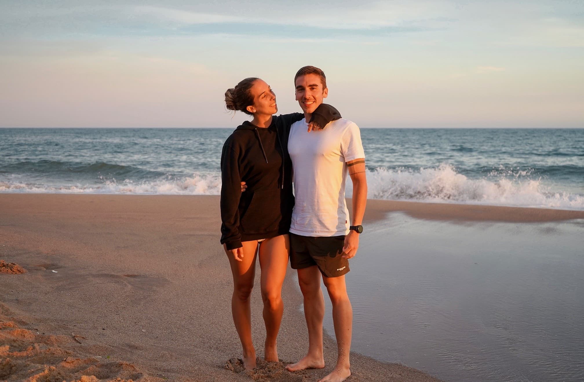 Pilar y Marcos abrazados en la playa frente al mar